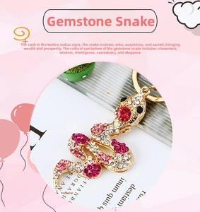 Close-up of snake keychain with sparkling pink and red rhinestones on gold metal