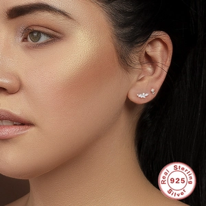 Close-up of S925 sterling silver zircon earrings worn on a model's ear cartilage