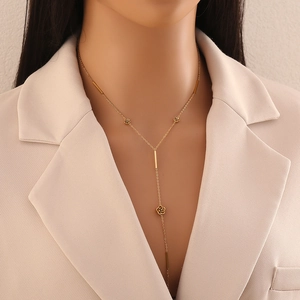 Collana a Y in acciaio placcato oro con ciondoli a rosa indossata da una modella
