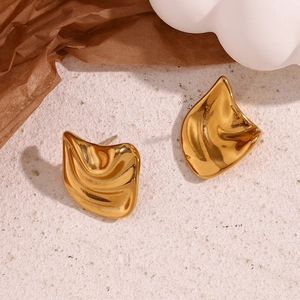 Detailed shot of irregular 18K gold plated stainless steel stud earrings on stone