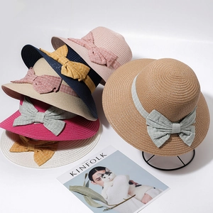Selection of wide-brim straw hats in various colors with decorative checkered bow knots