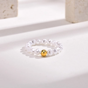 Minimalist beaded ring featuring irregular white pearls and a polished gold metal bead
