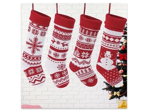 Detail of four red and white knitted Christmas stockings with snowflake and deer patterns