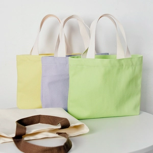 Selection of colorful canvas tote bags in yellow, purple, green, and cream with brown handles