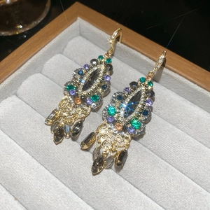 Detail of luxury colorful teardrop tassel earrings with vintage gold settings on display
