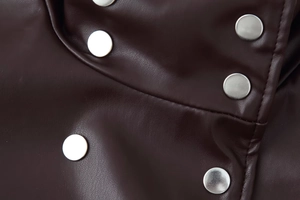 Detailed close-up of dark brown PU leather jacket with polished silver metal buttons