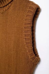 Close-up of caramel knitted sweater vest showing ribbed texture and premium wool material