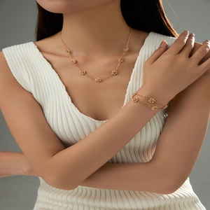 Detailed view of golden flower necklace and bracelet set with delicate pearl petals