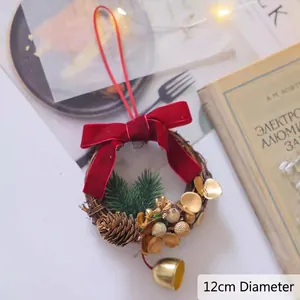 Détail d'une couronne de Noël de 12cm avec nœud en velours rouge et petits grelots
