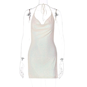 Close-up detail of white sequin texture on backless halter neck mini dress