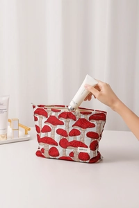 Placing hand cream into a vintage mushroom jacquard makeup bag to show storage capacity