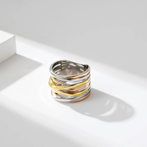 Detalle del anillo trenzado tricolor de acero inoxidable con sombras elegantes
