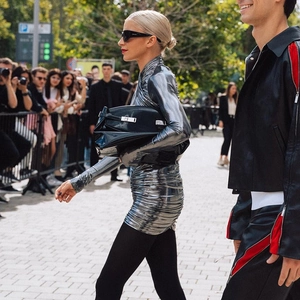 Detailopname van een zilveren metallic bodycon-jurk met lange mouwen en geplooide details
