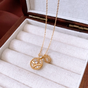 Macro shot of gold starburst necklace with zircon inlay on a wooden jewelry box