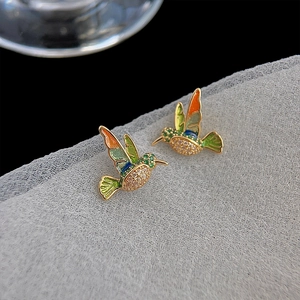 Macro view of colorful enamel hummingbird stud earrings with sparkling cubic zirconia