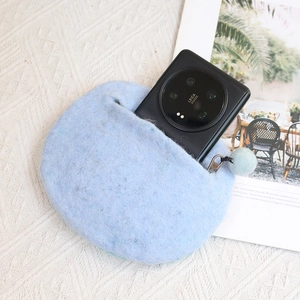 Cute light blue felt pouch with pom-pom zipper for phone and cards on textured background