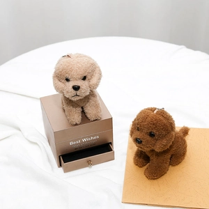 Close-up of beige and brown teddy dog plush keychains on decorative props