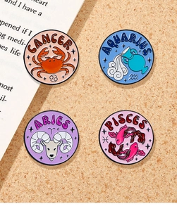 Detail of colorful enamel zodiac pins featuring Cancer, Aquarius, Aries, and Pisces