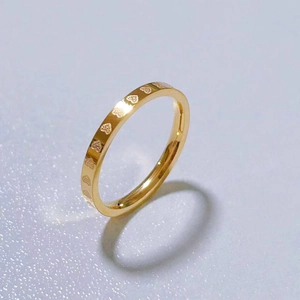 Gold plated stainless steel 2mm ring with heart patterns shown from a 45-degree angle