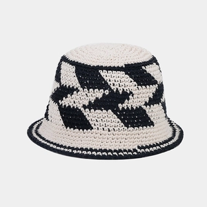 Close-up of geometric pattern on hand-crocheted cotton bucket hat in beige and navy