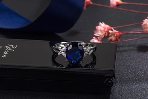 Macro view of blue sapphire style ring with marquise cut white zirconias on silver band