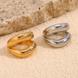 Macro detail of gold and silver irregular fluid lip rings on raw stone background