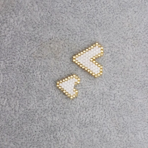 Handmade Miyuki bead heart charm in white and gold woven pattern for jewelry making
