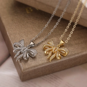 Exquisite gold and silver plated bow necklaces with zircon stones on a jewelry box