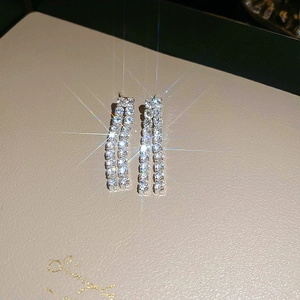 Detail of silver tassel earrings with double-row cubic zirconia and sparkling reflections