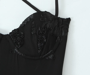 Close-up of three-dimensional fabric flower detail on a black corset mini dress