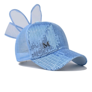 Détail d'une casquette en maille à paillettes bleu clair avec oreilles de lapin et logo M