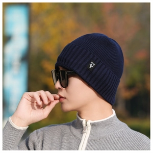 Detailed close-up of the thick knitted navy blue beanie with a decorative NY & JA side label