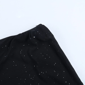 Detailed close-up of black mesh fabric featuring shimmering silver sequins and fine glitters