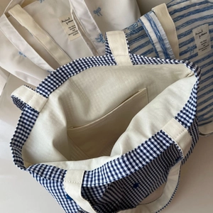 Detail of blue gingham canvas tote bag showing interior pocket and fabric texture