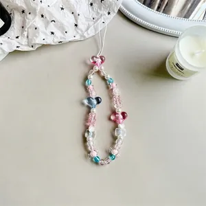 Close-up of handmade beaded wrist strap with heart resin beads and white pearls