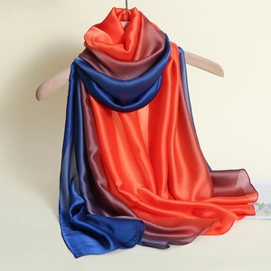 Detail eines Seidensatinschals mit Farbverlauf von Orange zu Dunkelbraun und Blau