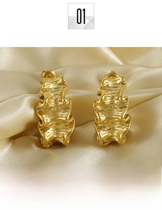 Macro shot of 18K gold plated irregular pleated texture on titanium steel earrings