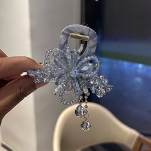 Detail of blue crystal bow hair claw clip with hanging tassel and elegant beads