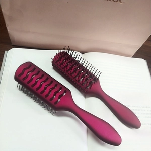 Dettaglio spazzole per capelli bordeaux opaco con design ventilato e manico ergonomico