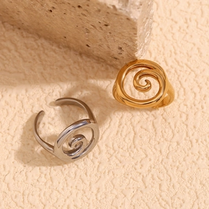 Minimalist spiral swirl open rings in gold and silver finish on a textured stone base