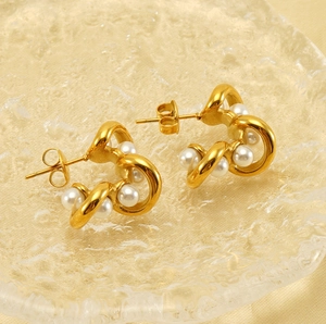 Detailed close-up of 18K gold-plated irregular C-shape pearl earrings on silk