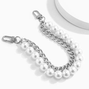 Detail view of silver metal chain with large white faux pearls and dual lobster clasps