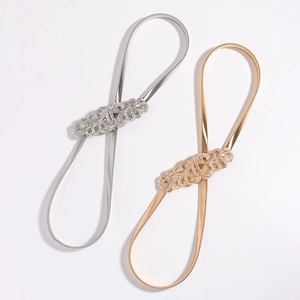 Detail of elastic spring waist belts in gold and silver with intricate filigree buckles