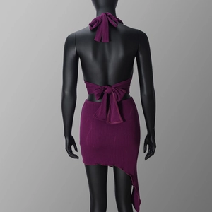Detail view of purple ribbed knit halter top with open back and asymmetric skirt on mannequin