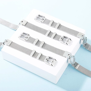 Detailed view of silver stainless steel mesh watch bands on a minimalist display