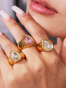 Détail de bague épaisse plaquée or 18 carats avec zircons en forme de goutte empilés sur la main