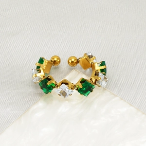 Macro shot of gold-plated ring featuring alternating emerald green and clear zircon stones