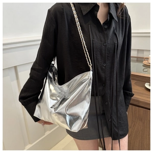 Detail of silver metallic hobo bag with gold chain strap and glossy reflective finish