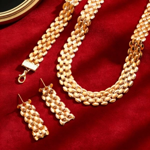 Detail of gold metal mesh jewelry set with necklace and earrings on red velvet