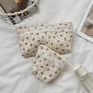 Close-up of floral makeup bags with delicate lace trim and red flower patterns